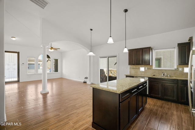 kitchen featuring decorative light fixtures, wood-type flooring, ceiling fan, and plenty of natural light