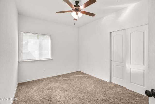 carpeted spare room with ceiling fan