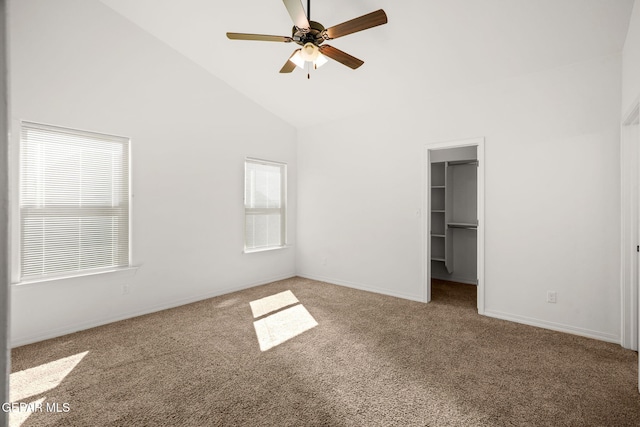 unfurnished bedroom with a closet, a spacious closet, ceiling fan, and carpet floors