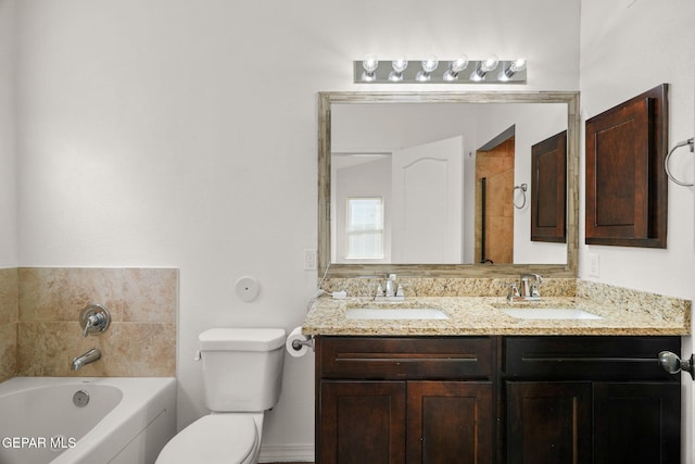 bathroom with toilet, vanity, and a bath