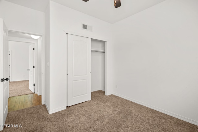 unfurnished bedroom with carpet, ceiling fan, and a closet