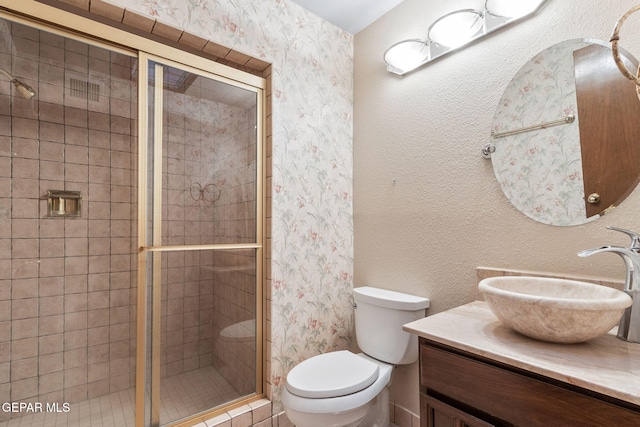 bathroom with vanity, toilet, and walk in shower