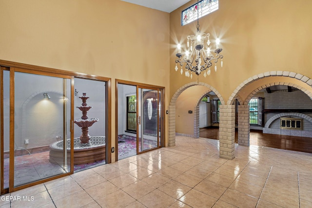 foyer featuring a towering ceiling, plenty of natural light, and light tile patterned floors