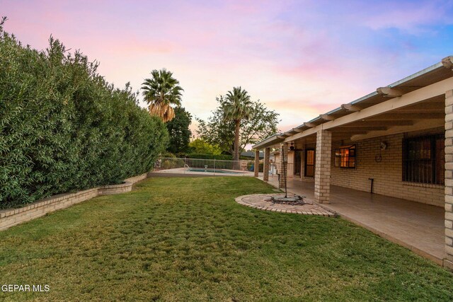 yard at dusk with a patio area and a pool