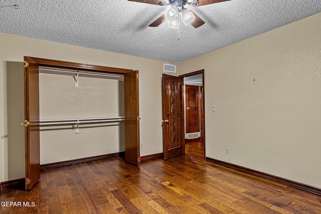 unfurnished bedroom featuring ceiling fan, dark wood-type flooring, and a textured ceiling