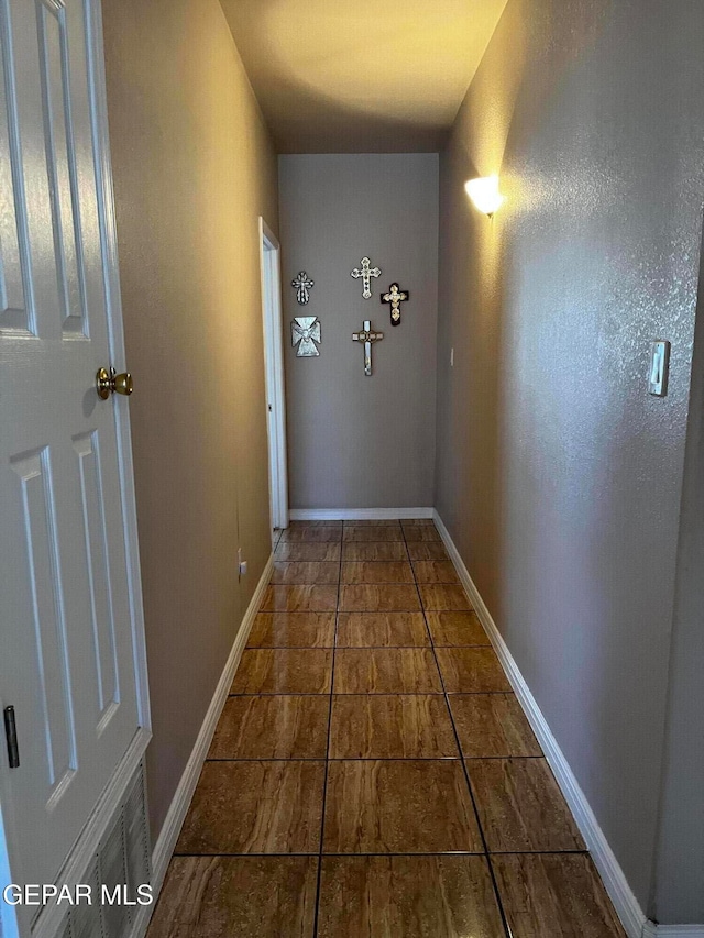 hallway with dark tile patterned floors