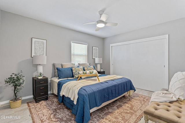 bedroom with ceiling fan, a closet, and wood-type flooring