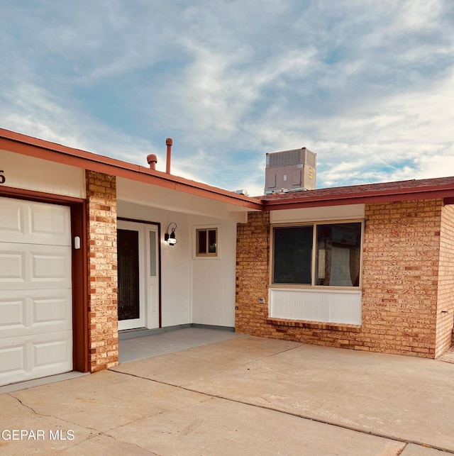 view of front facade with a garage and cooling unit