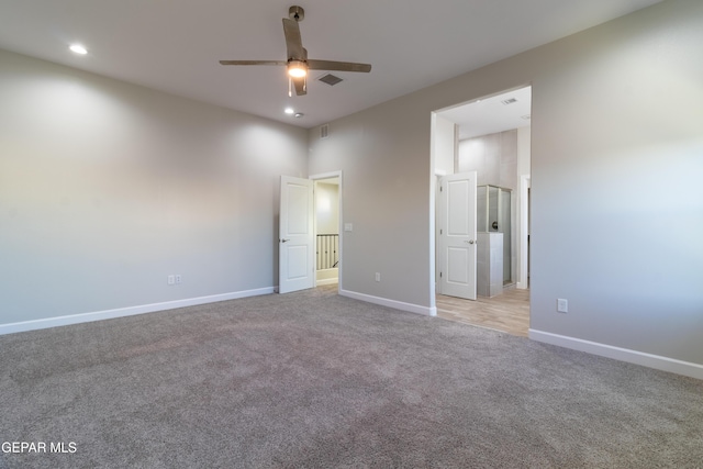 unfurnished bedroom with ceiling fan, light colored carpet, and a towering ceiling