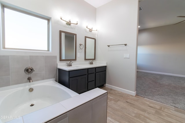 bathroom with a bathtub, vanity, and hardwood / wood-style flooring