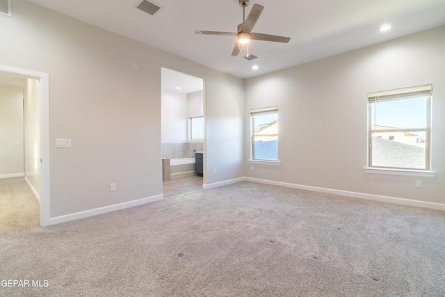 spare room featuring light colored carpet and ceiling fan