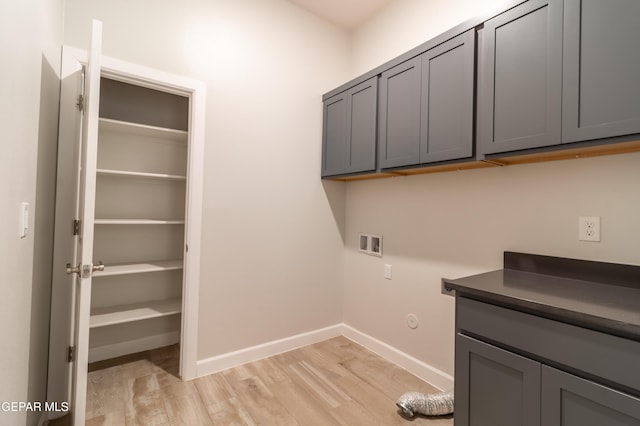 laundry room featuring hookup for a washing machine, cabinets, and light wood-type flooring