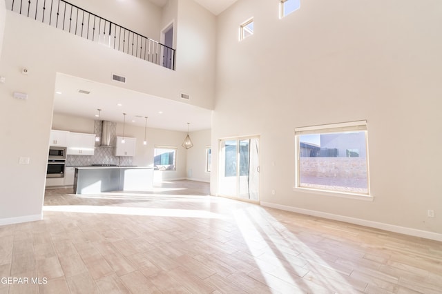 unfurnished living room featuring a high ceiling