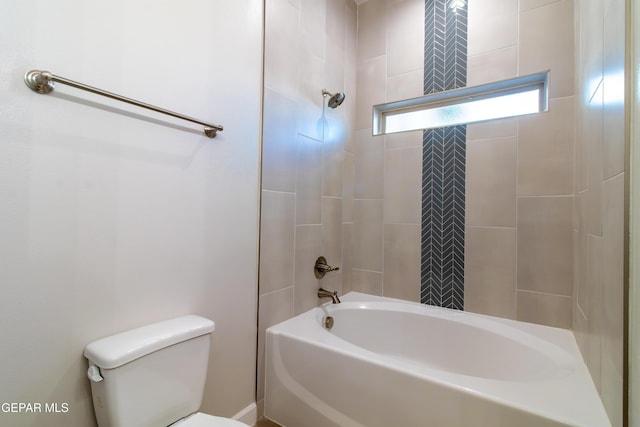 bathroom featuring toilet and tiled shower / bath