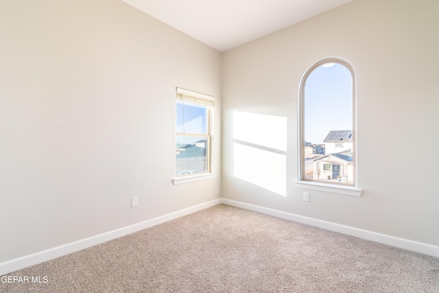 empty room with a healthy amount of sunlight and carpet floors