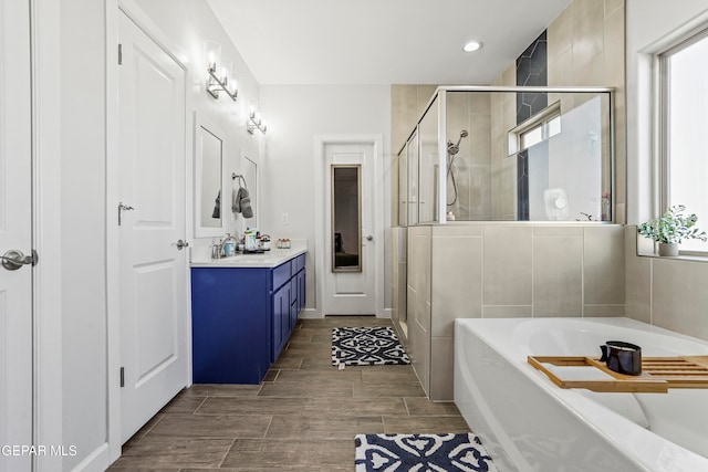 bathroom featuring vanity and shower with separate bathtub