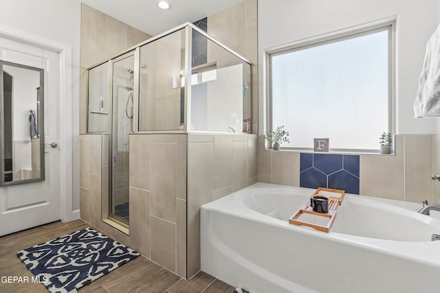 bathroom featuring independent shower and bath, hardwood / wood-style flooring, and a healthy amount of sunlight