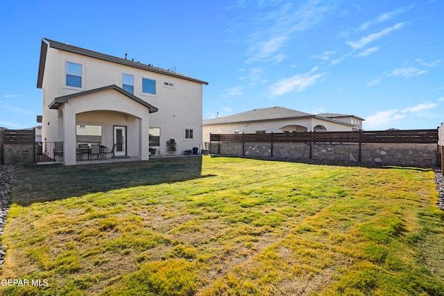 rear view of house featuring a patio and a yard