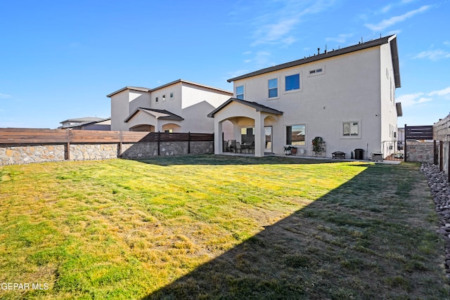 rear view of house with a yard and a patio area