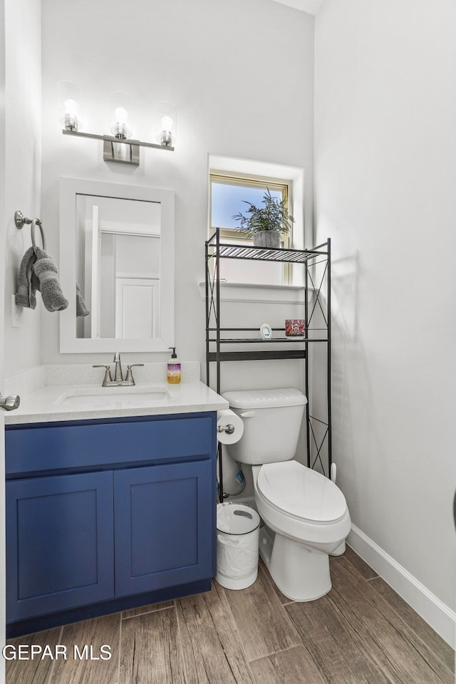 bathroom featuring wood-type flooring, vanity, and toilet