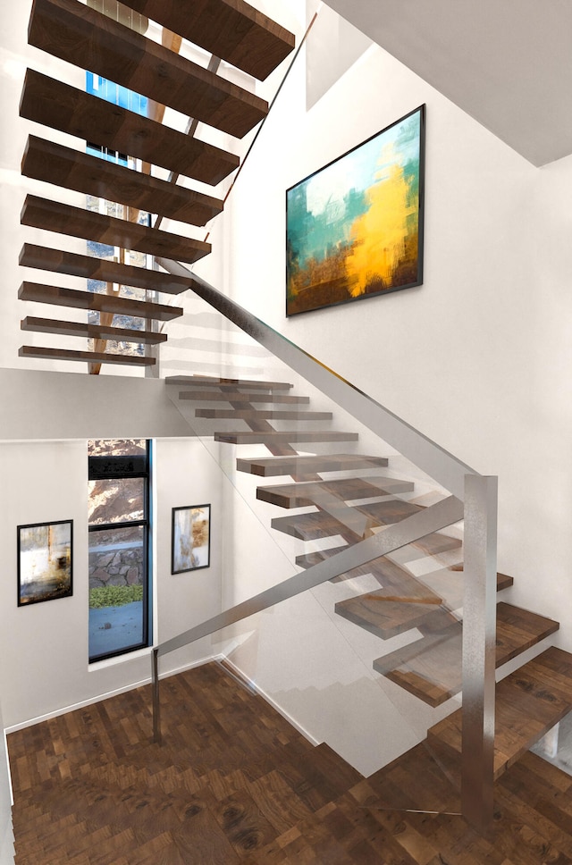 stairs featuring a high ceiling and hardwood / wood-style flooring