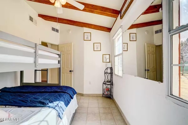 bedroom with ceiling fan, vaulted ceiling with beams, and light tile patterned floors