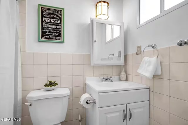 bathroom featuring tile walls, toilet, and vanity