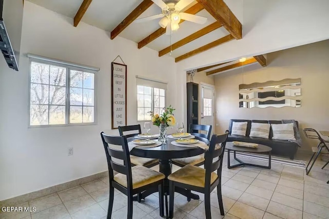 tiled dining room featuring ceiling fan, vaulted ceiling with beams, and plenty of natural light