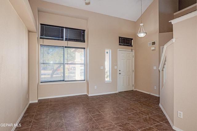 tiled entrance foyer with a towering ceiling