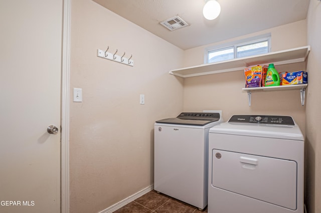 clothes washing area featuring washing machine and dryer and dark tile patterned floors