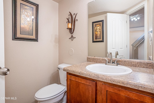 bathroom with vanity, ceiling fan, and toilet