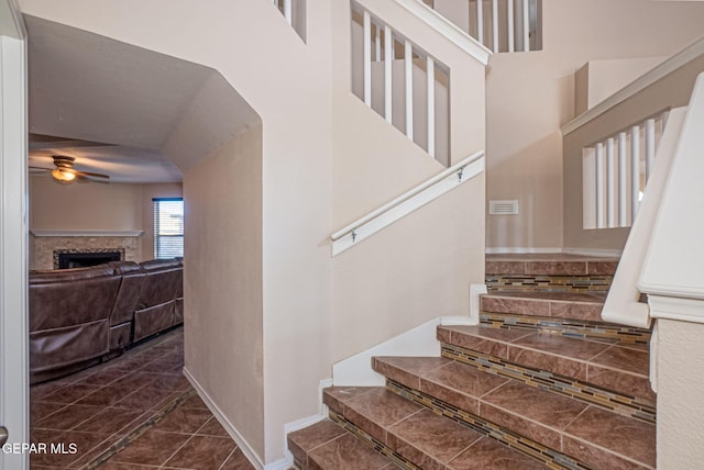 staircase featuring tile patterned floors and ceiling fan