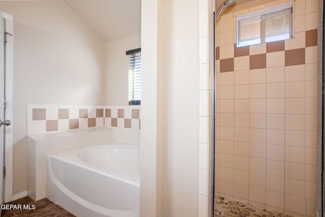 bathroom featuring independent shower and bath and vaulted ceiling