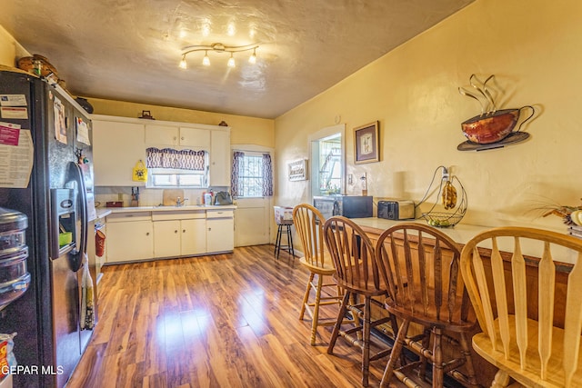 kitchen featuring fridge with ice dispenser, white cabinetry, light hardwood / wood-style flooring, and sink