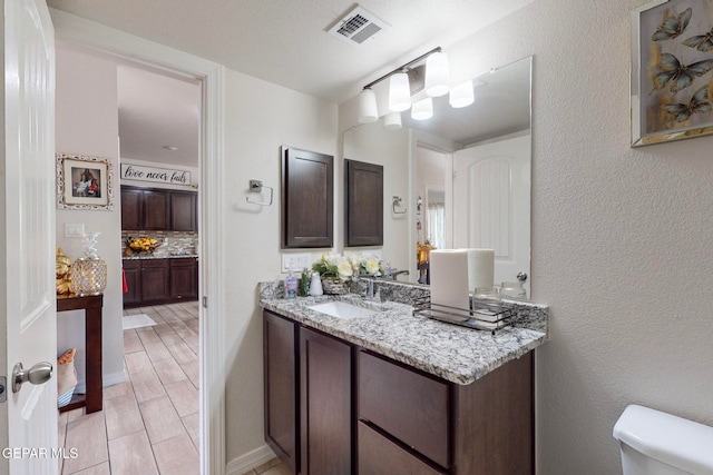 bathroom with hardwood / wood-style flooring, vanity, and toilet