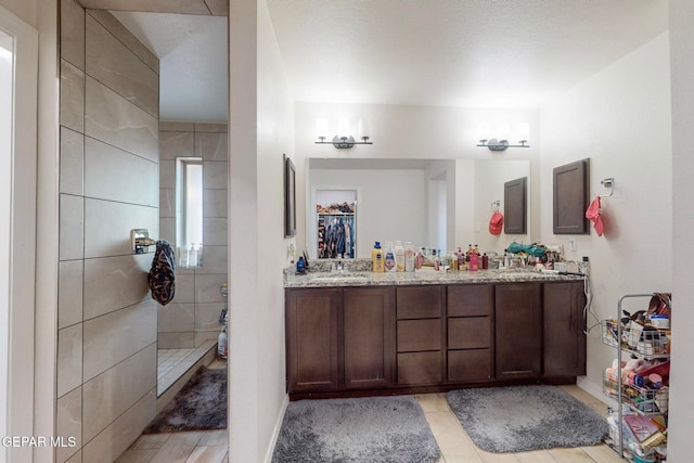 bathroom with vanity and tiled shower