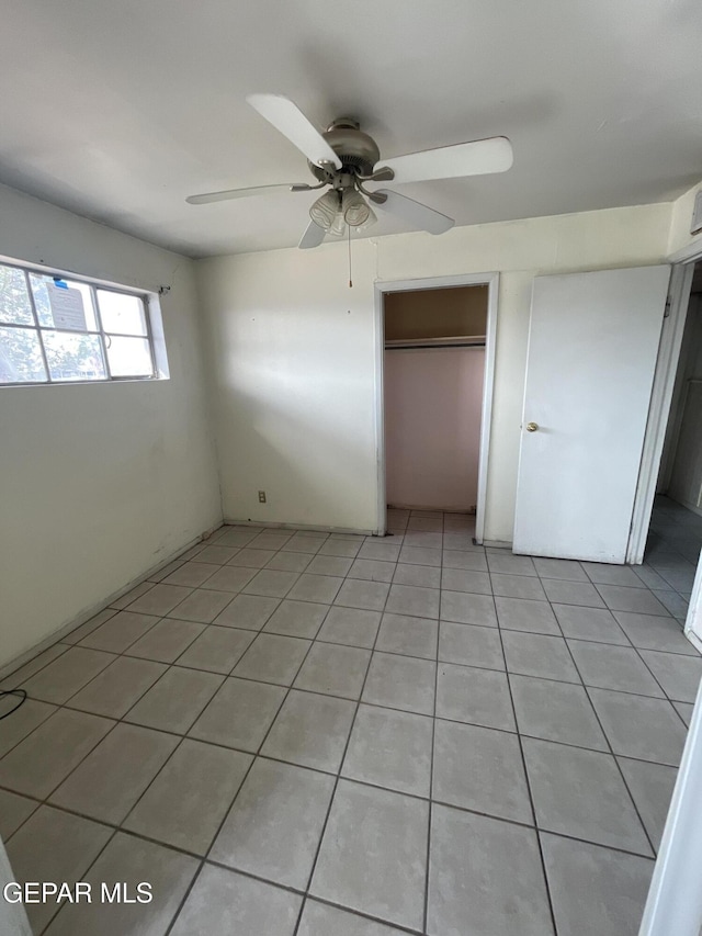 unfurnished bedroom with ceiling fan, light tile patterned floors, and a closet