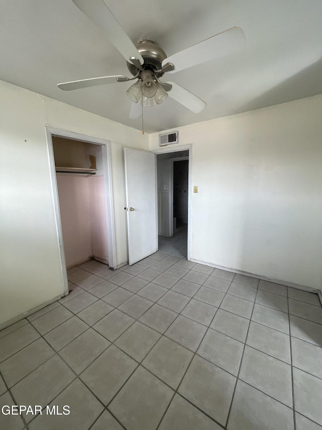 unfurnished bedroom with ceiling fan, light tile patterned floors, and a closet