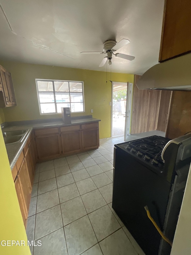 kitchen with ventilation hood, ceiling fan, sink, light tile patterned floors, and black range with electric stovetop