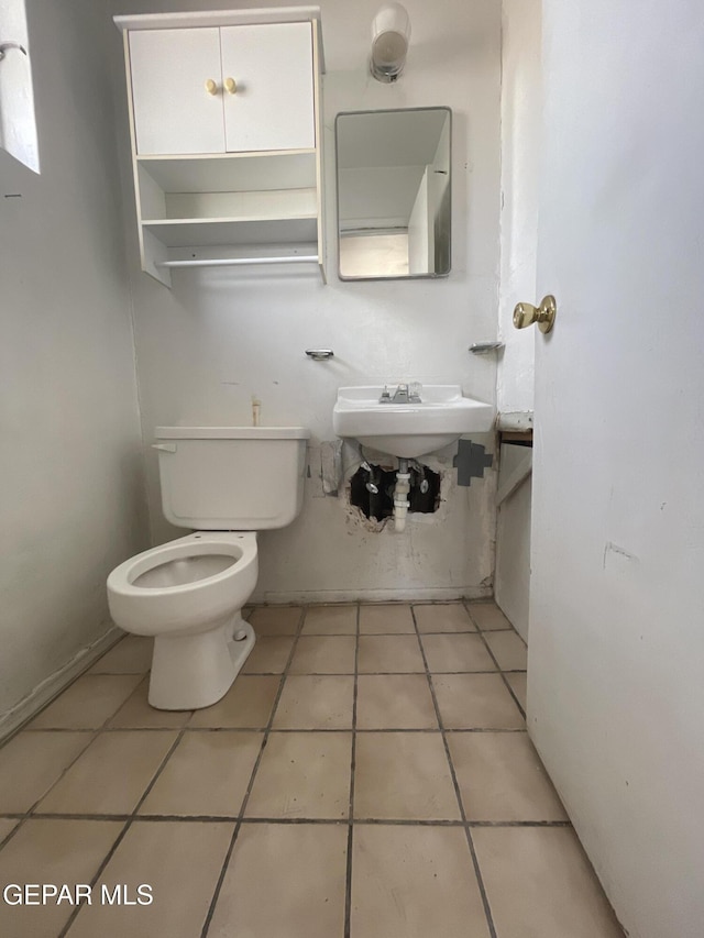 bathroom featuring sink, tile patterned flooring, and toilet