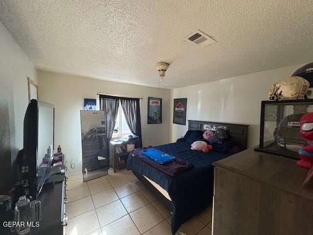 bedroom with light tile patterned floors and a textured ceiling