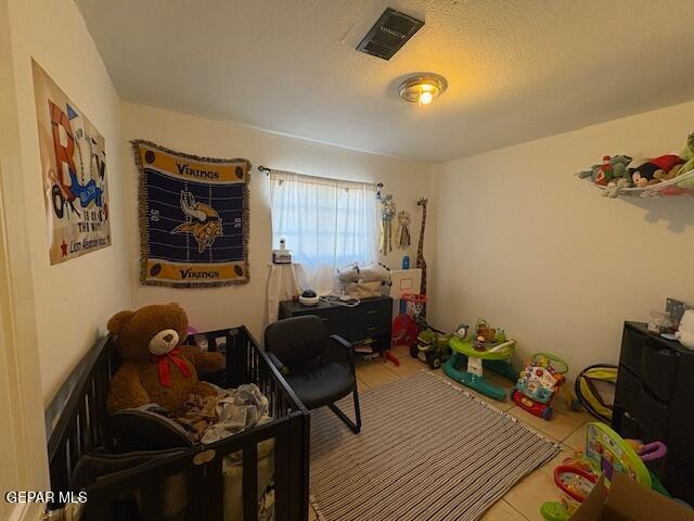 playroom featuring tile patterned floors and a textured ceiling