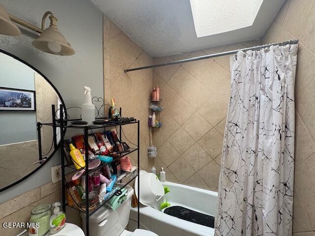 bathroom featuring shower / bath combo, toilet, and a skylight