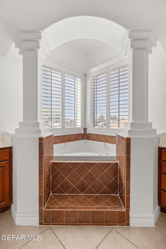 bathroom with vanity, tile patterned floors, a healthy amount of sunlight, and tiled tub