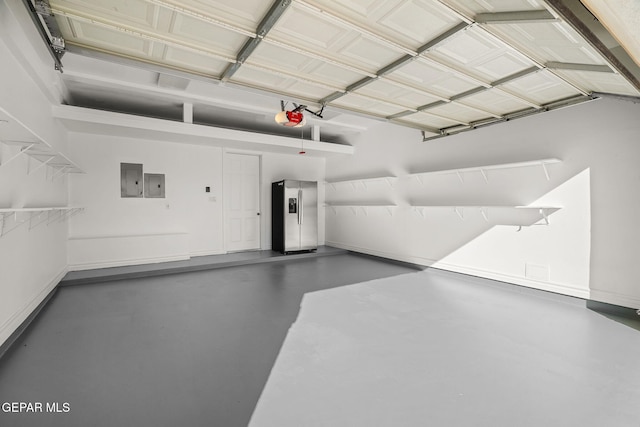 garage featuring electric panel, stainless steel fridge with ice dispenser, and a garage door opener