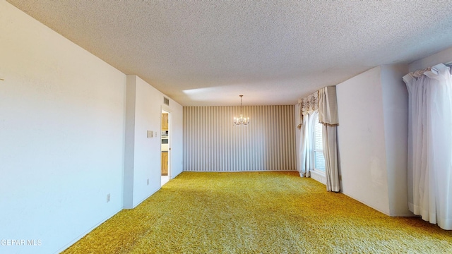 532 Satellite Dr, El Paso, TX 79912 - carpeted empty room featuring a textured ceiling and a notable chandelier