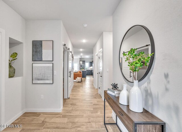 900 Stoke St, El Paso, TX 79928 - hall with light wood-style floors, baseboards, a barn door, and recessed lighting