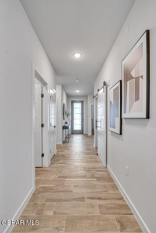900 Stoke St, El Paso, TX 79928 - hall with a barn door, baseboards, recessed lighting, and light wood-style flooring