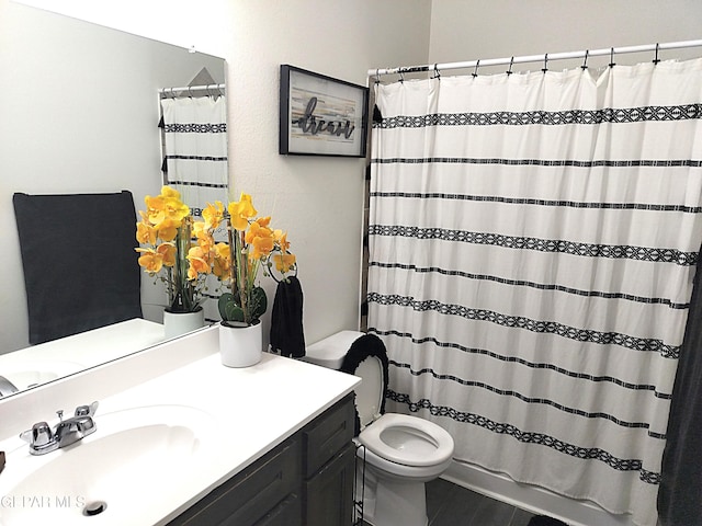 bathroom with tile patterned flooring, a shower with curtain, vanity, and toilet