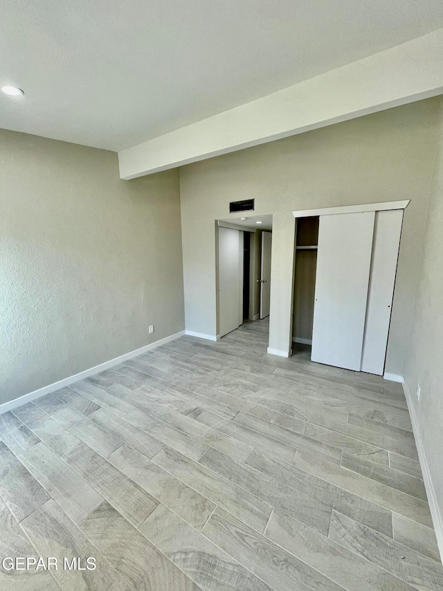 unfurnished bedroom with a closet and light hardwood / wood-style flooring